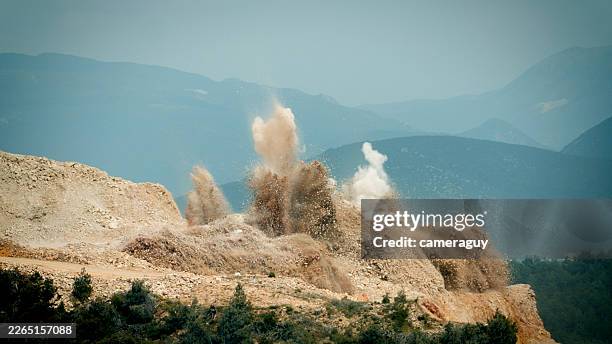 slow motion massive dynamite explosion at open-pit mine – large controlled blast during mineral exploration and industrial mining operation - bombers stock pictures, royalty-free photos & images