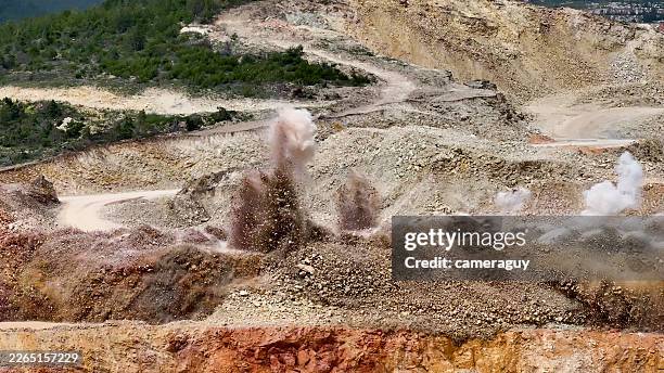 slow motion massive dynamite explosion at open-pit mine – large controlled blast during mineral exploration and industrial mining operation - gold mine stock pictures, royalty-free photos & images