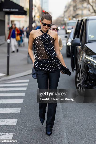 Guest wears transparent black white dots print top, pants, clutch outside Nina Ricci during Day Five of Paris Fashion Week - Womenswear Fall/Winter...