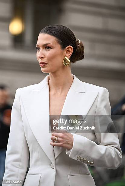 Danielle Copperman is seen wearing a white Nina Ricci suit and gold earrings outside the Nina Ricci show during Day Five of Paris Fashion Week -...