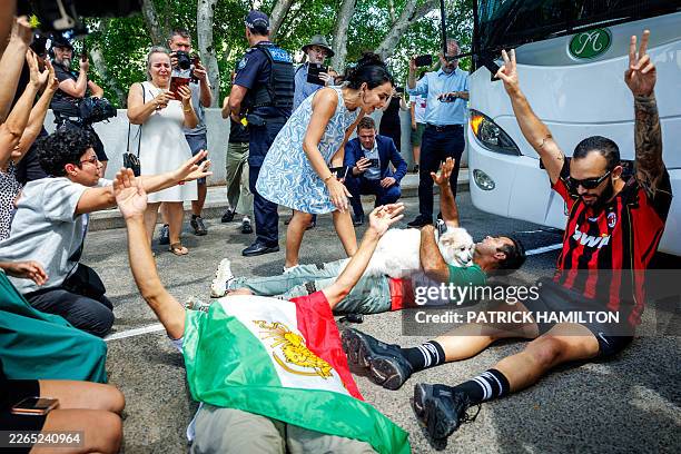 Members of the Iranian community in Australia block the path of a departing bus transporting members of the Iranian Women's Asia Cup football team to...