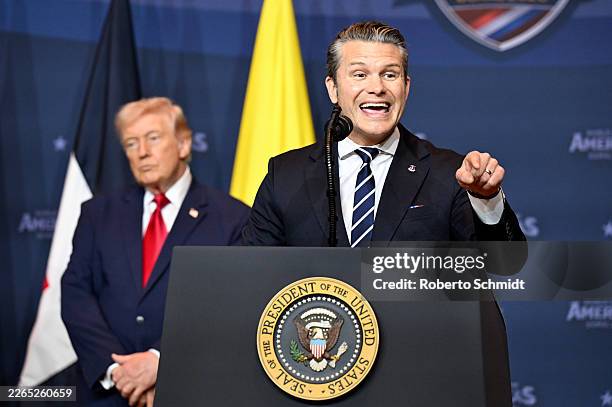 Defense Secretary Pete Hegseth addresses the audience as President Donald Trump listens during the “The Shield of the Americas Summit ,“ a gathering...