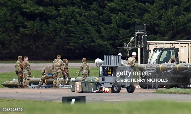 Members of the US Air Force prepare munitions at RAF Fairford in south-west England on March 10 after USAF B-1 Lancer bomber jets and Air Force...