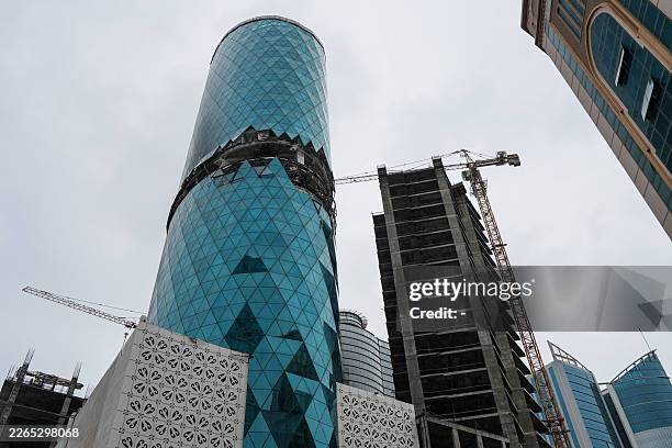 Photograph shows a damaged building in the aftermath of a drone strike in the Seef district of Manama on March 10, 2026. The oil-rich Gulf has borne...