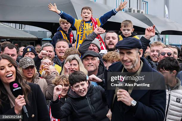 Mansfield Town supporters enjoy the pre match atmosphere behind TNT Sports presenter Martin Keown prior to the Emirates FA Cup Fifth Round match...