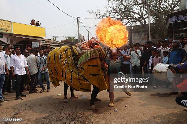 Devotee fire eater performs stunts and a traditional dance before devotees carry idols of Hindu gods and goddesses through the waters of Chilika Lake...