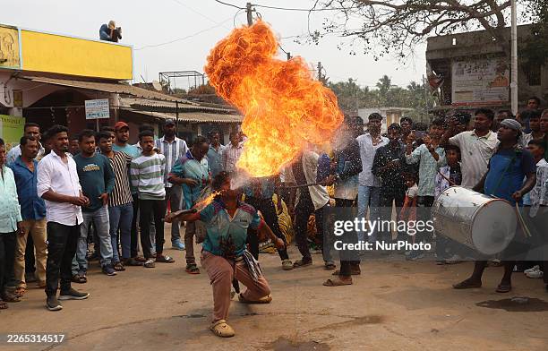 Devotee fire eater performs stunts and a traditional dance before devotees carry idols of Hindu gods and goddesses through the waters of Chilika Lake...