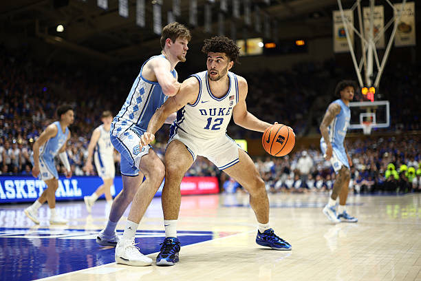Cameron Boozer of the Duke Blue Devils posts up against Henri Veesaar of the North Carolina Tar Heels during the second half of the game at Cameron...