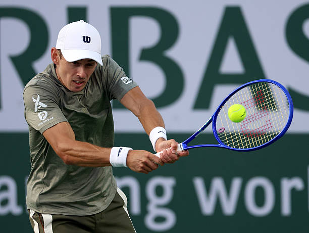Alex De Minaur of Australia plays a backhand in a match against Sebastian Korda of the United States during Day 4 of the BNP Paribas Open at Indian...