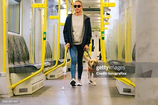 guide dog leads a blind person through the train compartment - visual impairment stock pictures, royalty-free photos & images