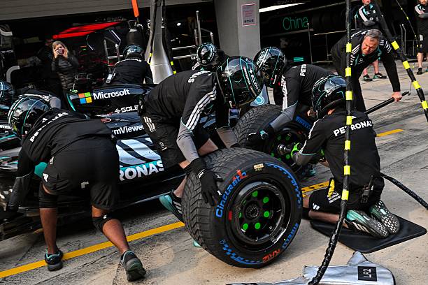 Mercedes team members practice a pit stop with the car of Mercedes' British driver George Russell ahead of the Formula One Chinese Grand Prix at the...