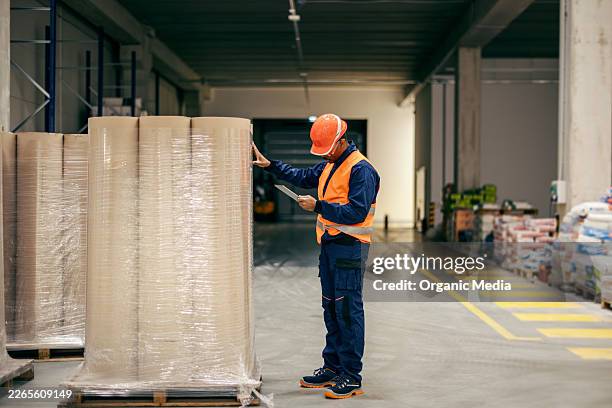 worker checking inventory using digital tablet in warehouse - checking boxes stock pictures, royalty-free photos & images