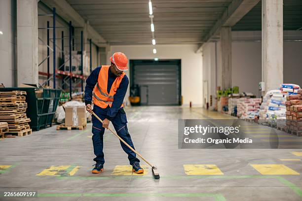 warehouse worker sweeping floor wearing safety gear - sweeping stock pictures, royalty-free photos & images
