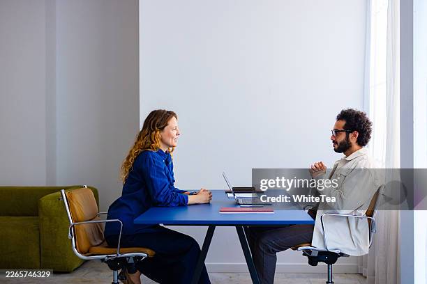 entretien professionnel dans un bureau moderne entre collègues - face à face photos et images de collection