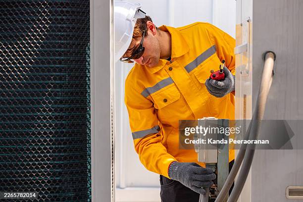 industrial technicians inspecting rooftop utility systems - temperature sensor stock pictures, royalty-free photos & images