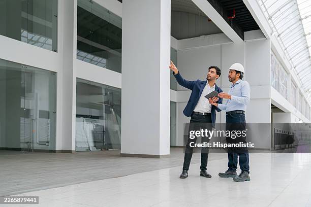 real estate developer talking to an architect while building a shopping mall - property developer stock pictures, royalty-free photos & images