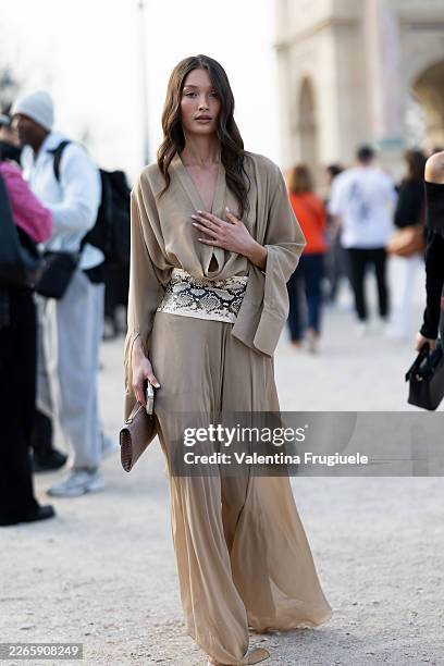 Yada Villaret wears a beige v-neck long sleeved long dress, a snake leather belt and a beige leather bag outside Elie Saab show during Day Six of...