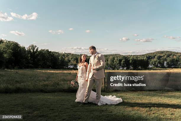 retrato romántico de boda al aire libre de una novia y un novio caminando de la mano por suecia - puesta de sol romántica fotografías e imágenes de stock