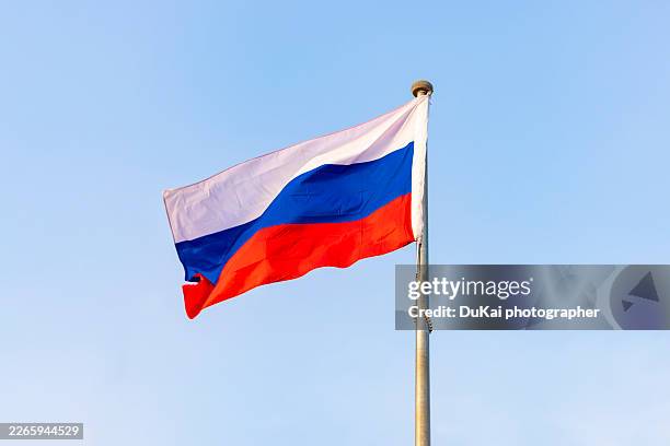 russia flag on blue clear sky - russian flag stock pictures, royalty-free photos & images
