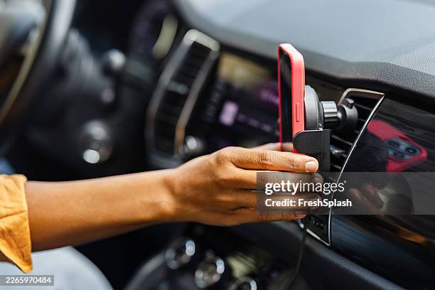 driver mounting smartphone in car with one hand - car interior stock pictures, royalty-free photos & images