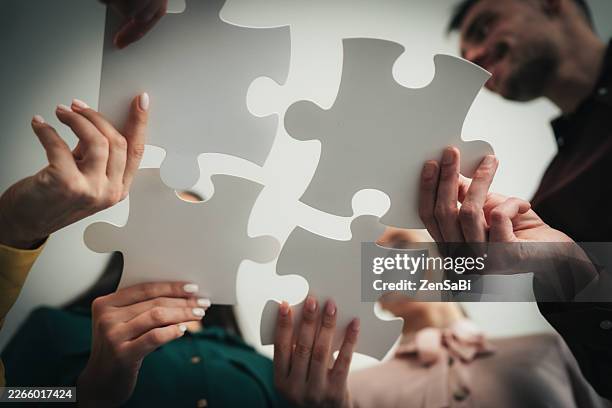 team collaboration concept with puzzle pieces - jigsaw piece stock pictures, royalty-free photos & images