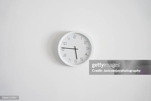 a contemporary, simple clock in black and white on a white wall - afternoon stock pictures, royalty-free photos & images