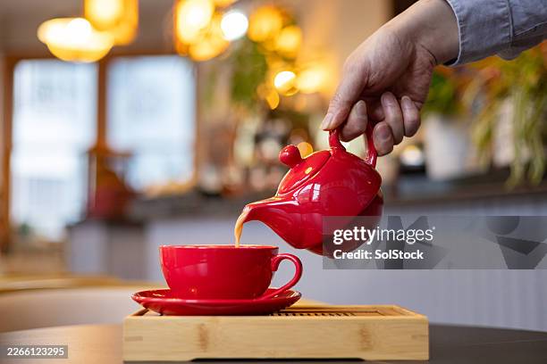 pouring a cup of tea - tea cup stock pictures, royalty-free photos & images