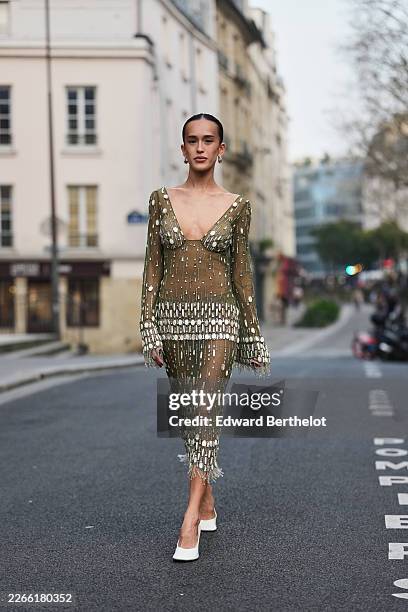 Guest wears black hair in a bun, silver earrings, a green sheer mesh with embroidered mirror embellished long flared sleeve / V-neck / fitted midi...