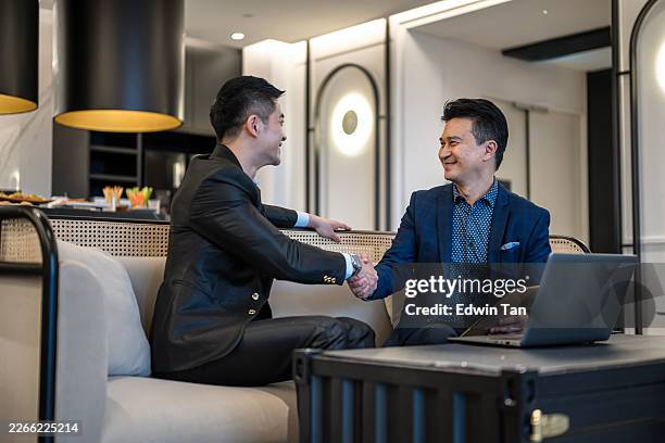 asian businessmen shaking hands after successful business meeting in kuala lumpur - monopoly hotel stock pictures, royalty-free photos & images