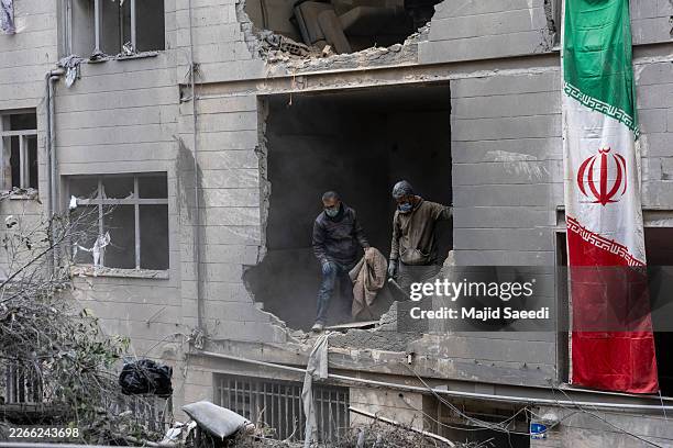 People clear rubble in a house in the Beryanak District after it was damaged by missile attacks two days before, on March 15, 2026 in Tehran, Iran....