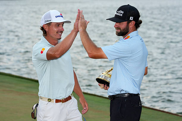 Cameron Young high-fives his caddie Kyle Sterbinsky during a trophy ceremony after winning THE PLAYERS Championship at Stadium Course at TPC Sawgrass...