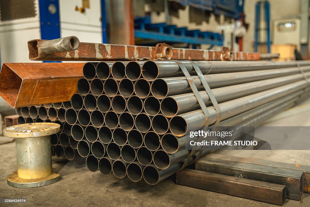 Stacked steel pipes arranged in warehouse ready for industrial construction use.