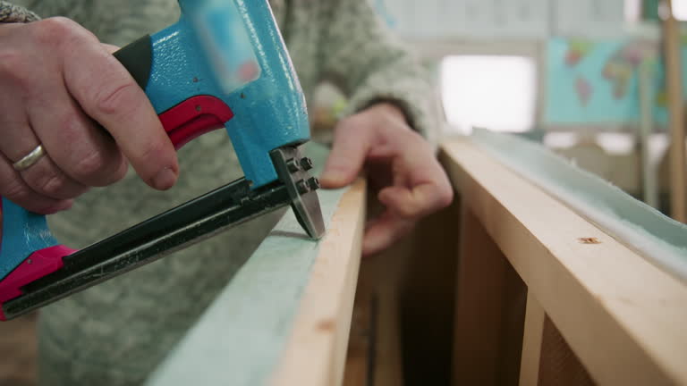 https://media.gettyimages.com/id/2266438080/video/male-upholsterer-attaching-fabric-to-a-wooden-frame-with-a-staple-gun.jpg?b=1&s=640x640&k=20&c=jOSdPGpbnh8Bj_9tpw2aGFjyZKDdc8lGwm0T42nh12s=