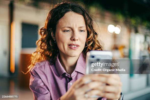 concerned woman using smartphone having communication issues - phone screen reflection stock pictures, royalty-free photos & images