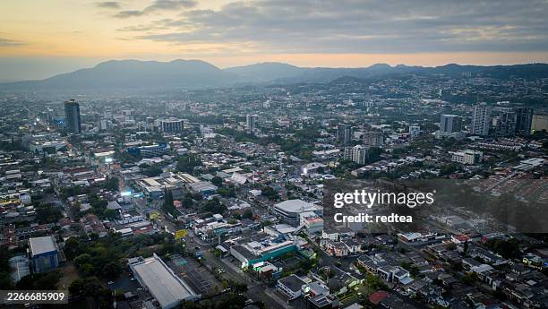 aerial view of san salvador cityscape at twilight with mountain background - san salvador stock pictures, royalty-free photos & images