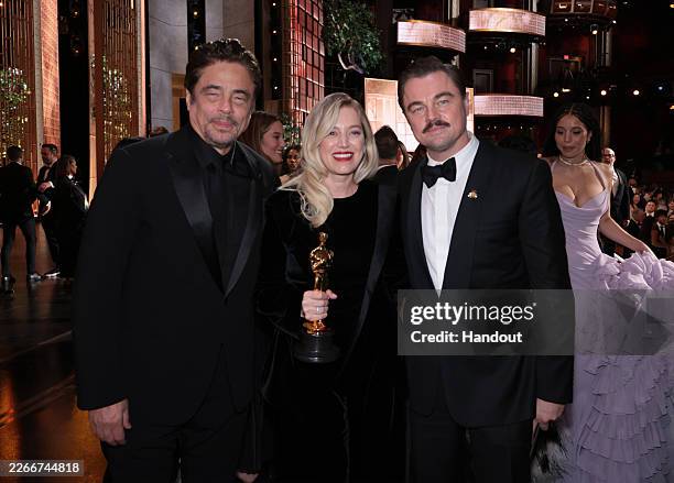 In this handout photo provided by The Academy, Benicio del Toro, Sara Murphy and Leonardo DiCaprio pose backstage after winning the award for Best...
