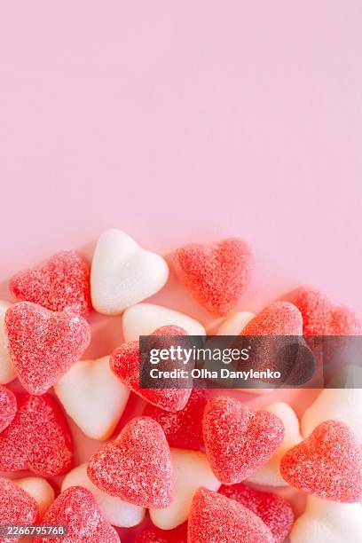 close-up of red and white heart shaped gummy candies on pink background - jellybean stock pictures, royalty-free photos & images