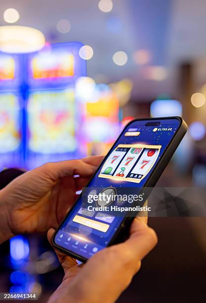 player winning the jackpot while gambling online on his cell phone - gambling stock pictures, royalty-free photos & images