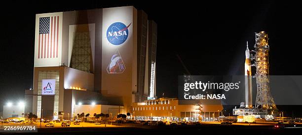 In this handout image provided by NASA, NASA's Space Launch System rocket and Orion spacecraft, secured to the mobile launcher, is seen as it rolls...
