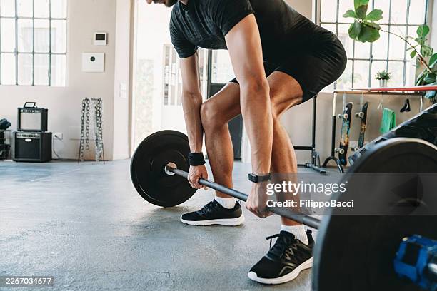 young man performing deadlift exercise in gym - deadlift stock pictures, royalty-free photos & images