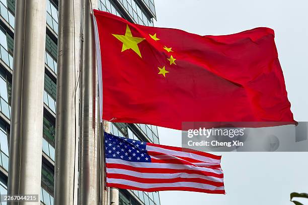 The national flags of China and the United States are seen flying outside a commercial building on March 17, 2026 in Hong Kong, China.