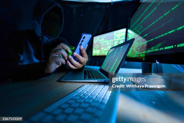 hacker using smartphone and laptop for cybercrime - dark web stock pictures, royalty-free photos & images