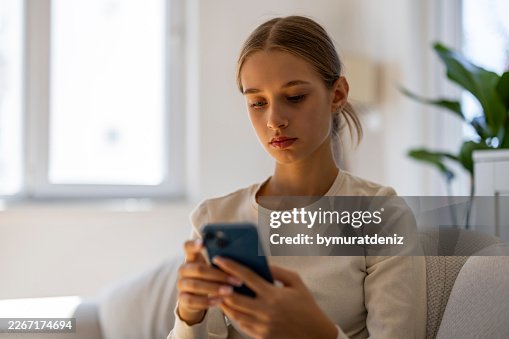 Young Woman Using Smartphone at Home Young Woman Using Smartphone at Home