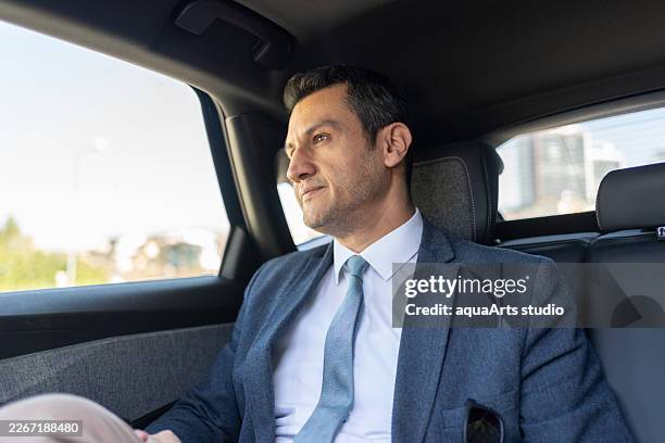 uomo d'affari in giacca e cravatta che viaggia in taxi - completo da uomo foto e immagini stock