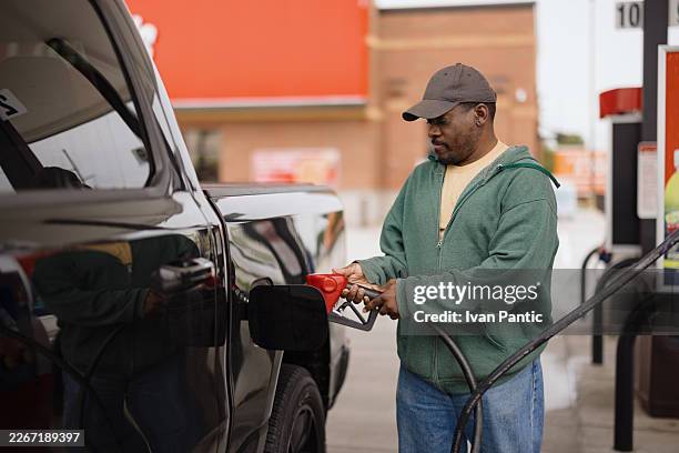 man fueling truck with gasoline at gas station - refueling stock pictures, royalty-free photos & images