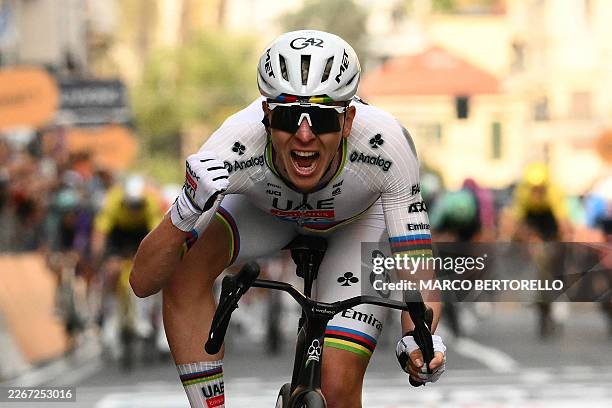 Team Emirate's Slovenian rider Tadej Pogacar celebrates as he crosses the finish line to win the 117th Milan - Sanremo one-day classic cycling race,...