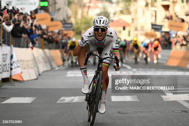 Team Emirate's Slovenian rider Tadej Pogacar celebrates as he crosses the finish line to win the 117th Milan - Sanremo one-day classic cycling race,...