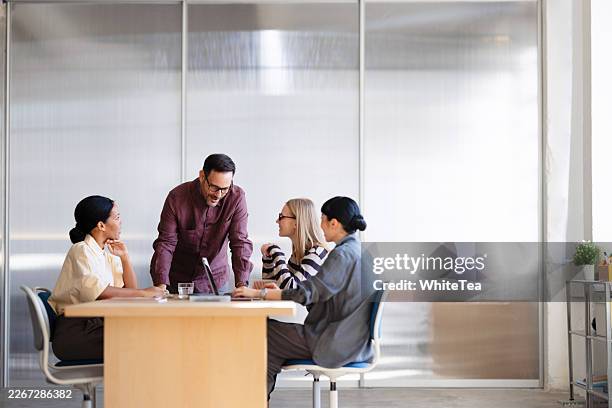 business team collaborating around table in office - modern design studio stock pictures, royalty-free photos & images