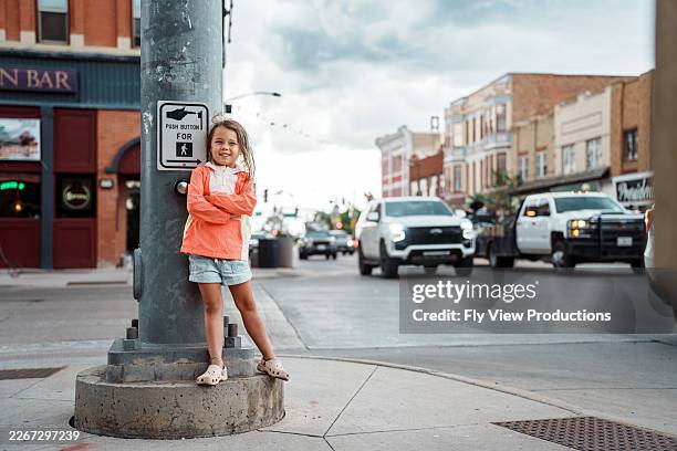 smiling girl waiting at crosswalk in downtown cheyenne, wyoming - afternoon stock pictures, royalty-free photos & images