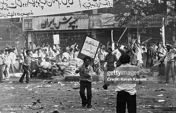 Men carrying placards and sticks during street battles in Tehran, Iran, 1979.